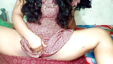 Indian brunette in a black dress seduces in a bedroom