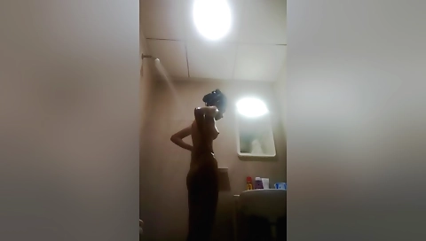 Busty brunette in a sexy dress gets naked in the shower