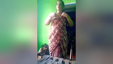 Indian girl in red dress plays with hair in the room