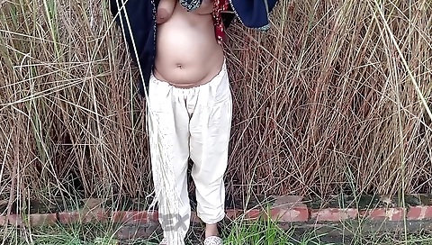 Indian woman enjoying her husband's car in the open field